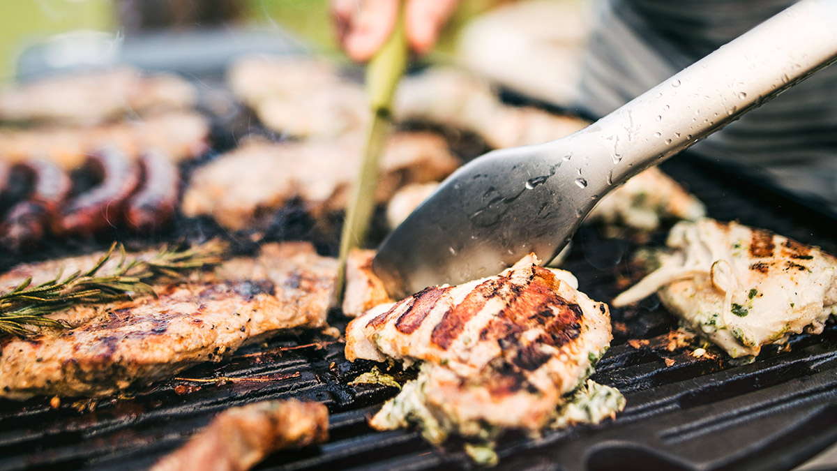 Man grillar kött och korv
