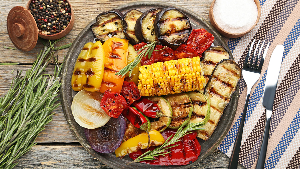 Vegetarisk grillad måltid med majs, paprika, tomater, zucchini, chili och lök
